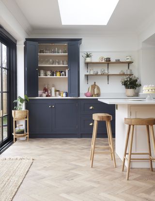 dark blue kitchen with grey island and large rooflight