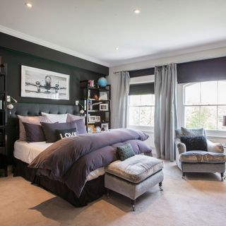 bedroom with grey armchair curtains and open shelf