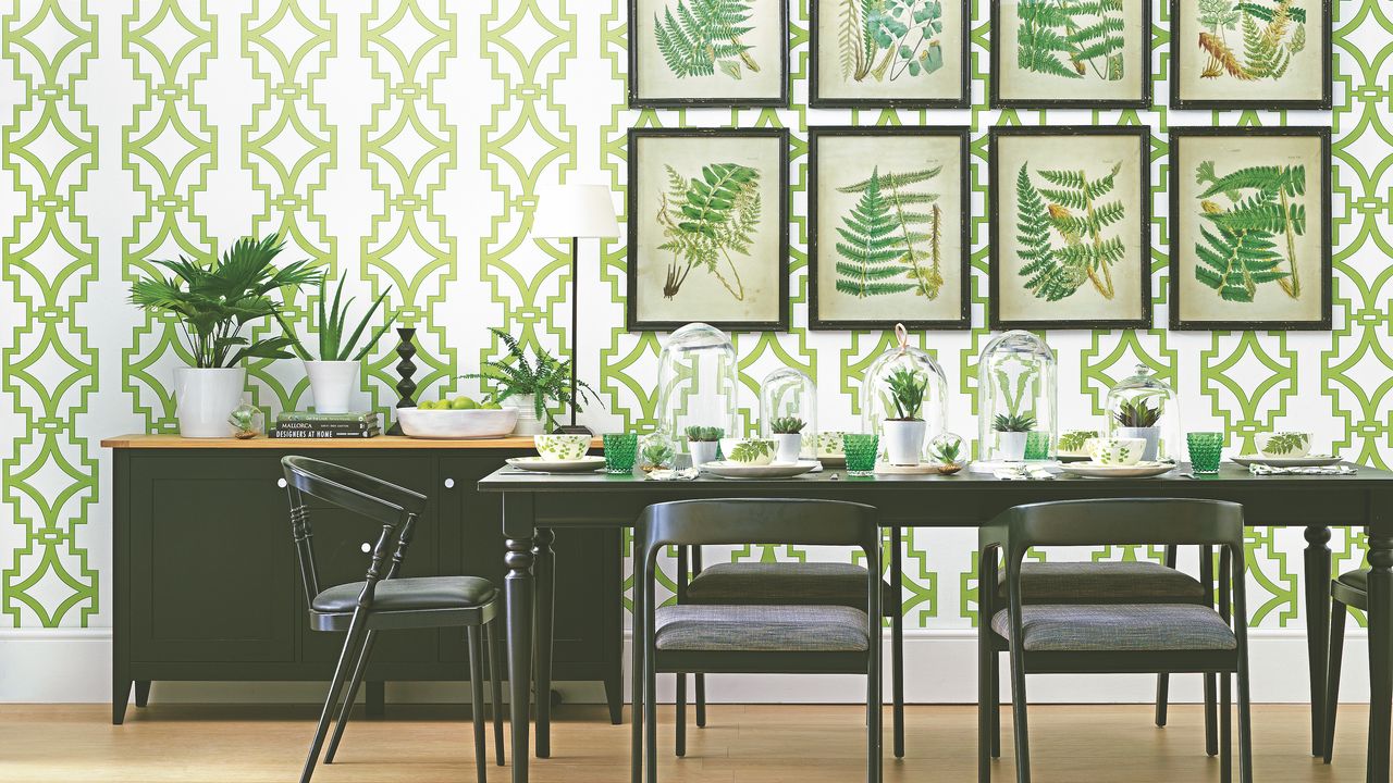 dining room with green graphic walllpapaer, artworks and black table and chairs