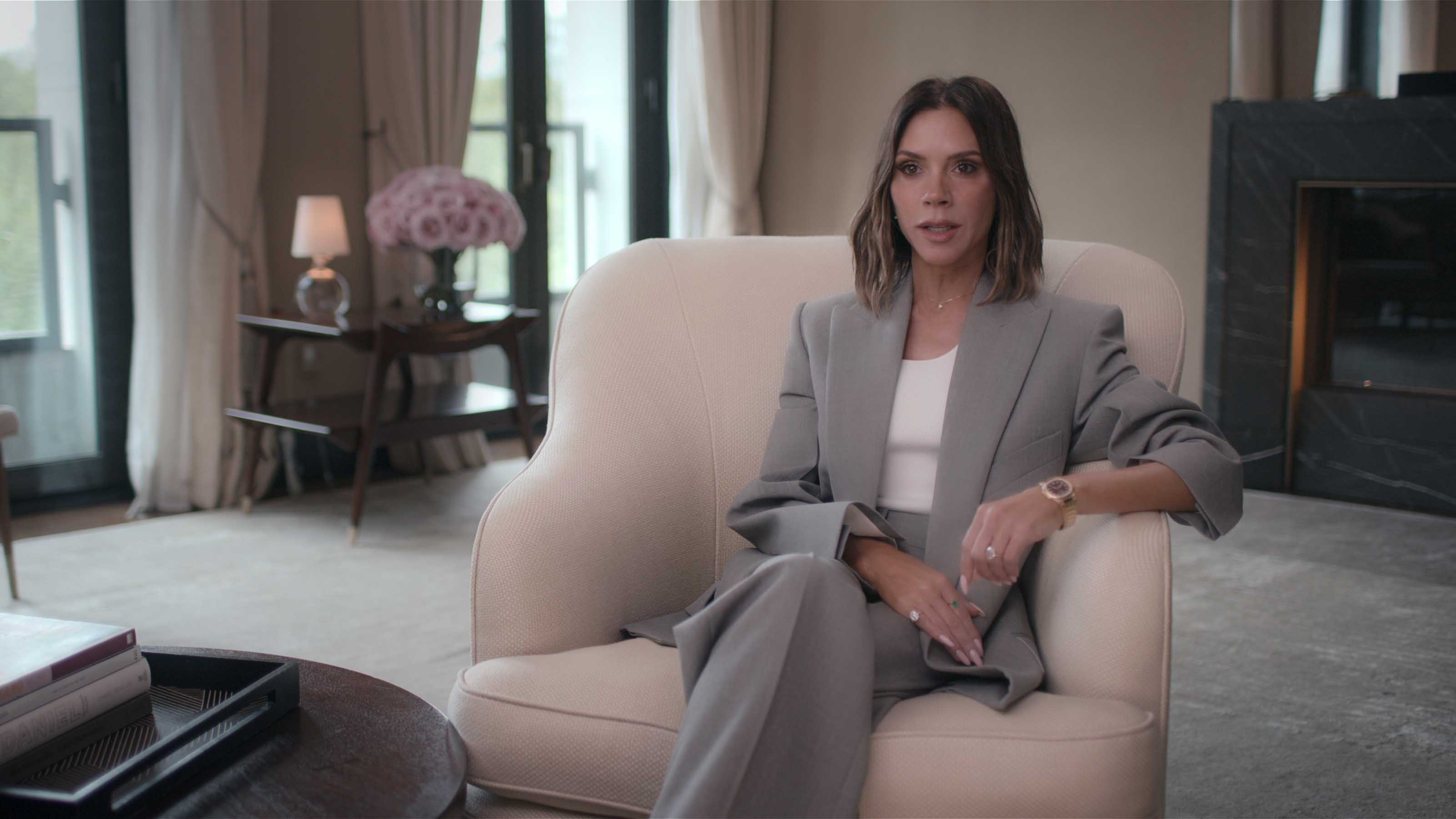Victoria Beckham sat on cream armchair