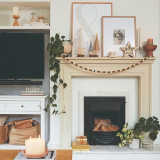 A living room with a fireplace decorated with a felt pom pom Christmas garland