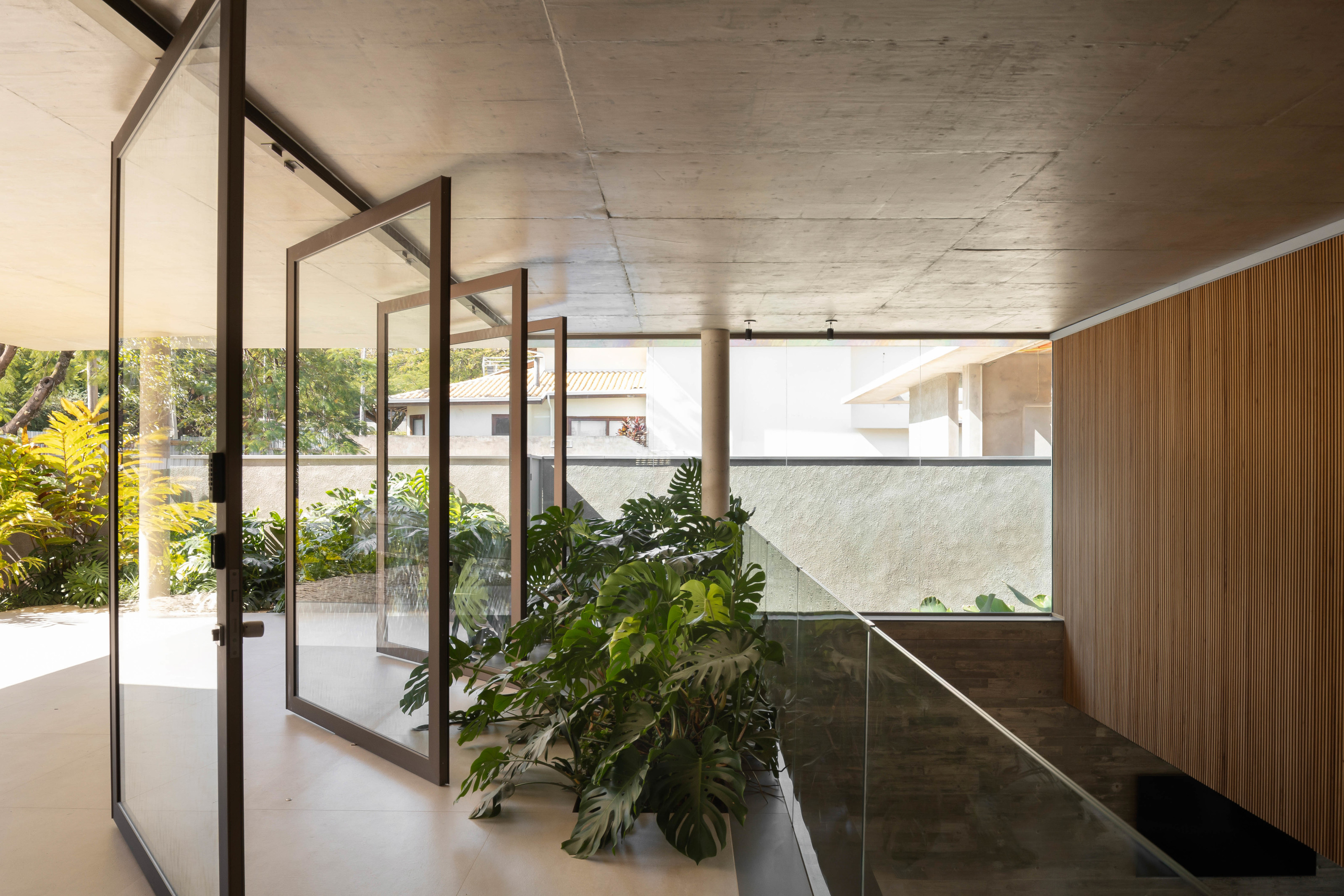 The glazed entrance hallway brings light into the double-height stairwell at right