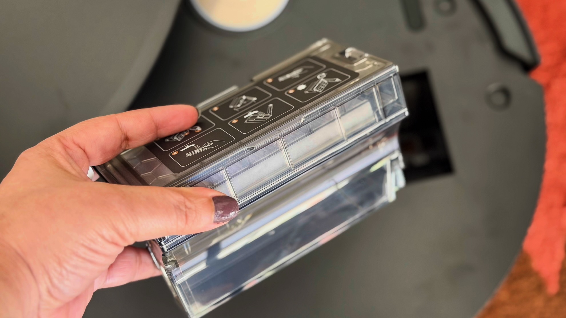 A hand holding Dreame Aqua10 Ultra's small onboard bin