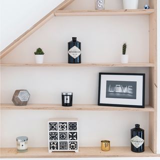wood shelves on white wall with pots and frames