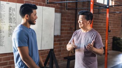Two men talking in gym setting