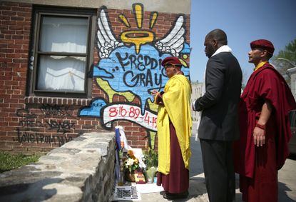 The Buddhist leader of South Asia says a prayer at the spot where Freddie Gray was arrested.