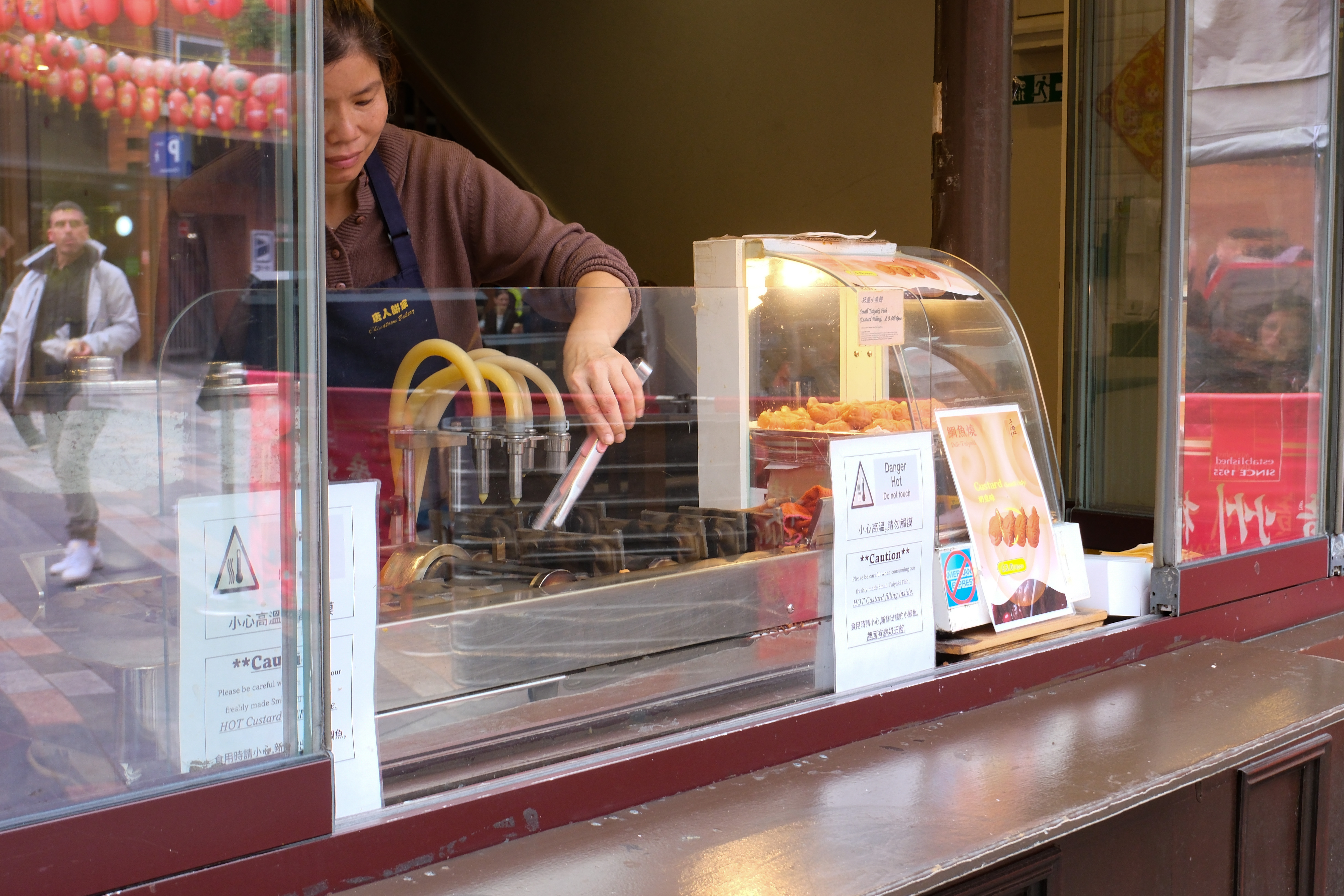 A person serving food in a window of a restaurant