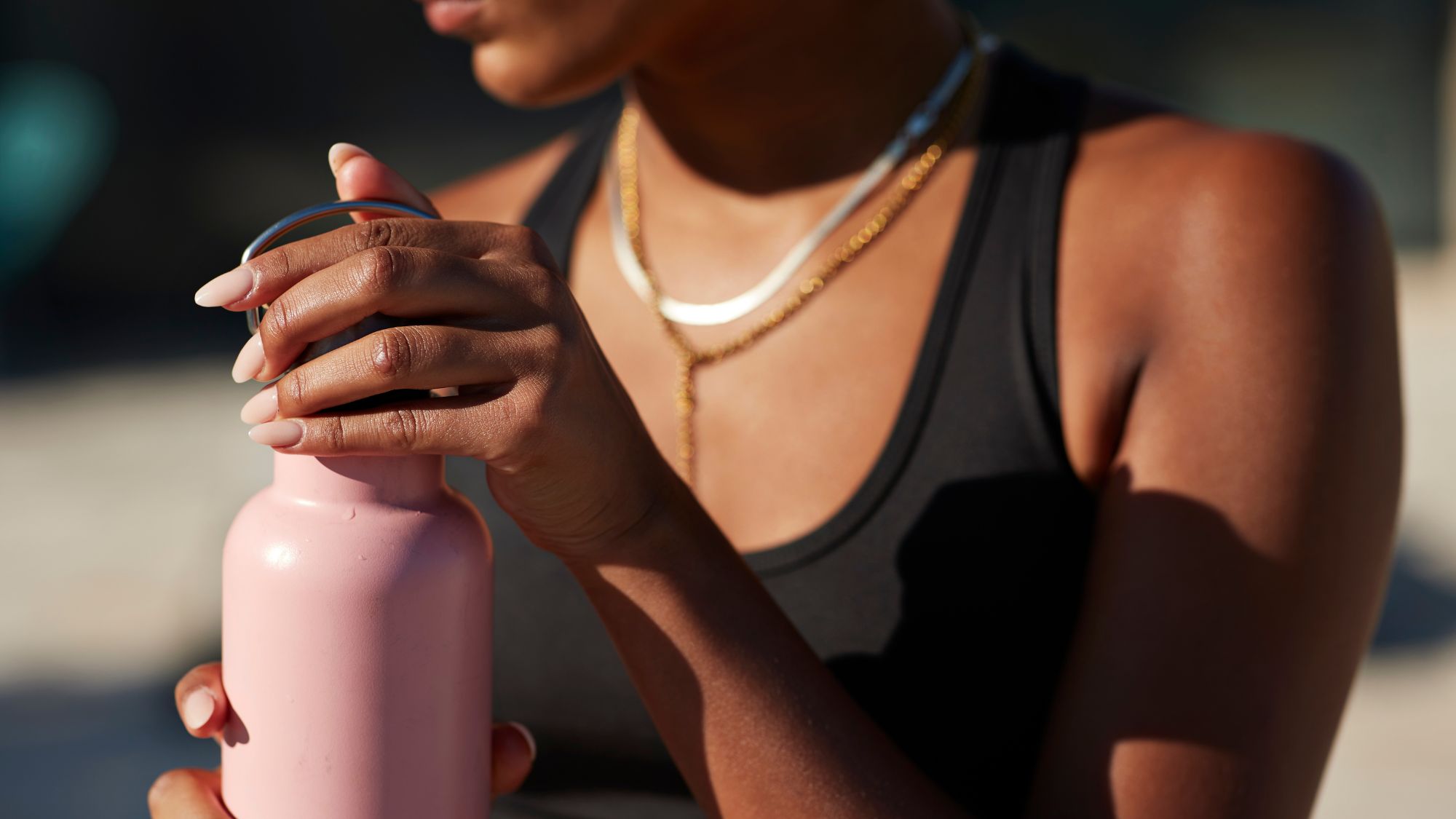 woman holding a pink water bottle