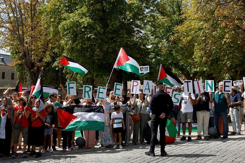 Guardia Civil officers stand as Pro-Palestinians protesters hold Palestinian flags and letters reading &#039;Free Palestine&#039; during the 20th stage of the Vuelta a Espana 2025, a 156 km race between Robledo de Chavela and Bola del Mundo, in El Escorial, on September 13, 2025. (Photo by Pierre-Philippe MARCOU / AFP)