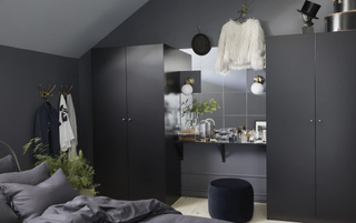 A dark bedroom with mirror and two closets either side