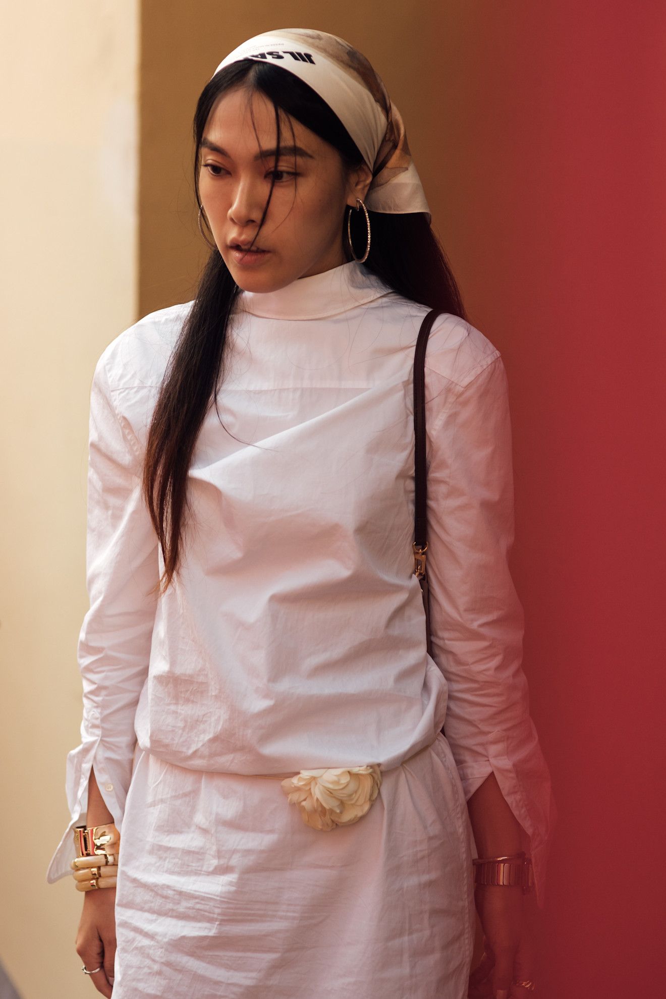 Milan Mens Fashion Week Showgoer wears a headscarf over her hair outside on the streets in Milan.