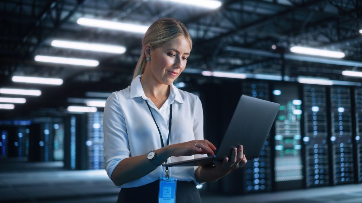 Woman with laptop in datacentre