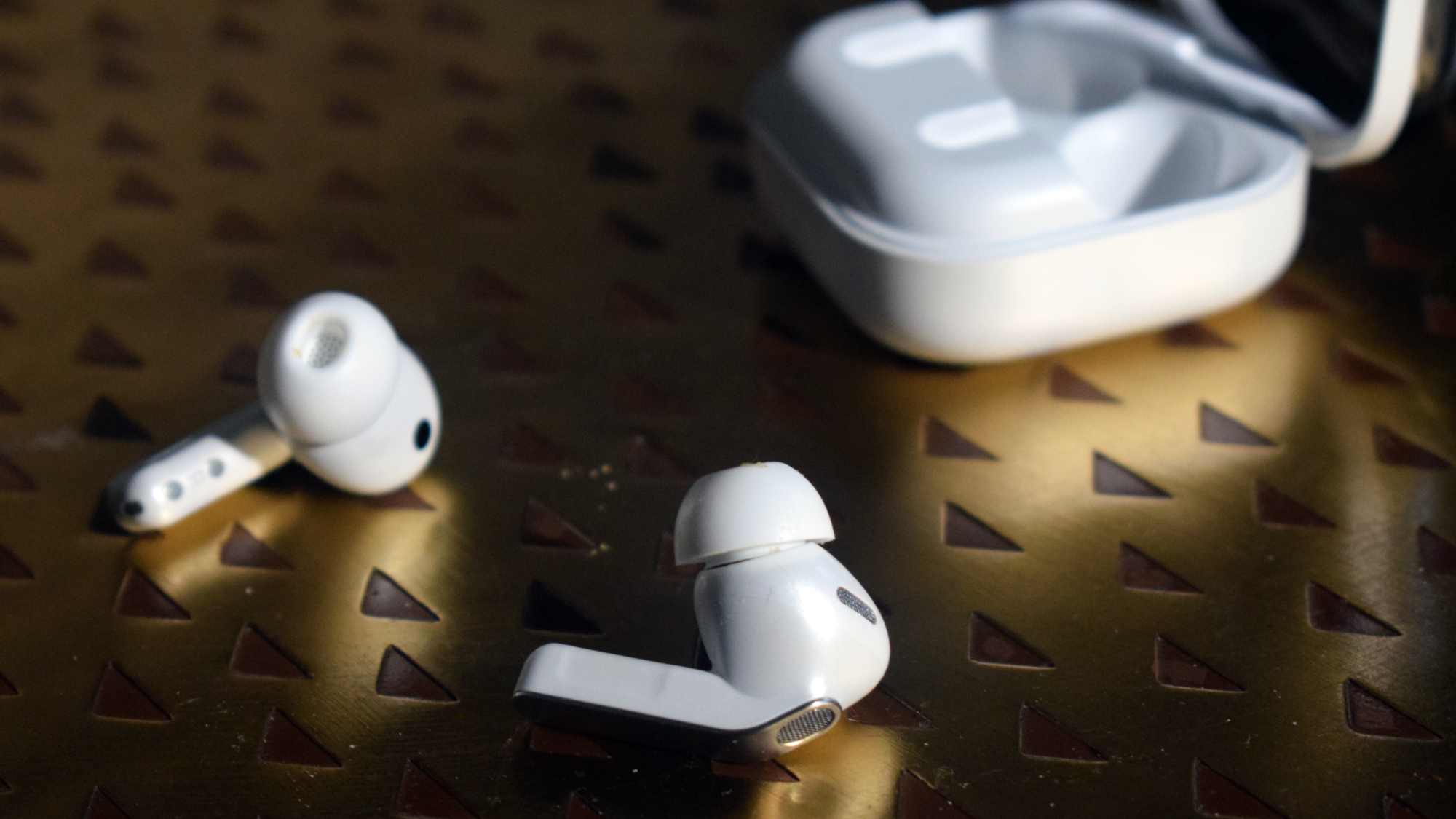 The Samsung Galaxy Buds 4 Pro buds on a table, next to their case.