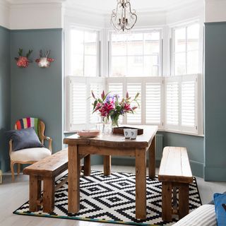 dining room with blue wall and wooden dining table with wooden bench