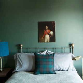 bedroom with grey wall and frame on wall with table lamp