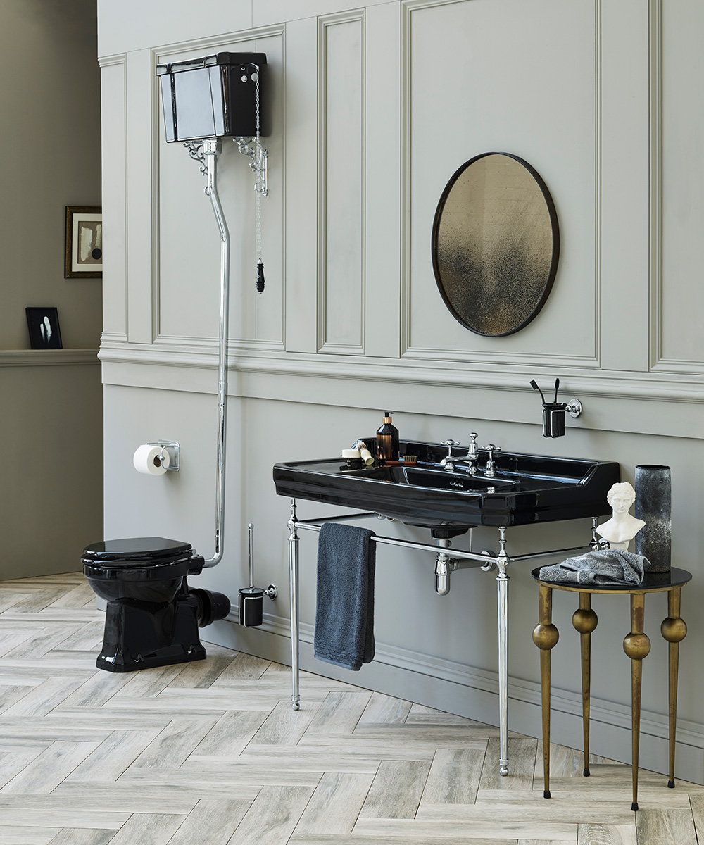 A grey panelled bathroom with black toilet and sink.