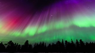 Aurora appear as curtains of light, stretching up through the sky. They are brightly colored starting as green closer to the ground then changing to purple and scarlet red.