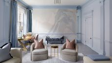 Powder blue living room with gold accents and Fromental wallpaper with abstracts swirls and shading