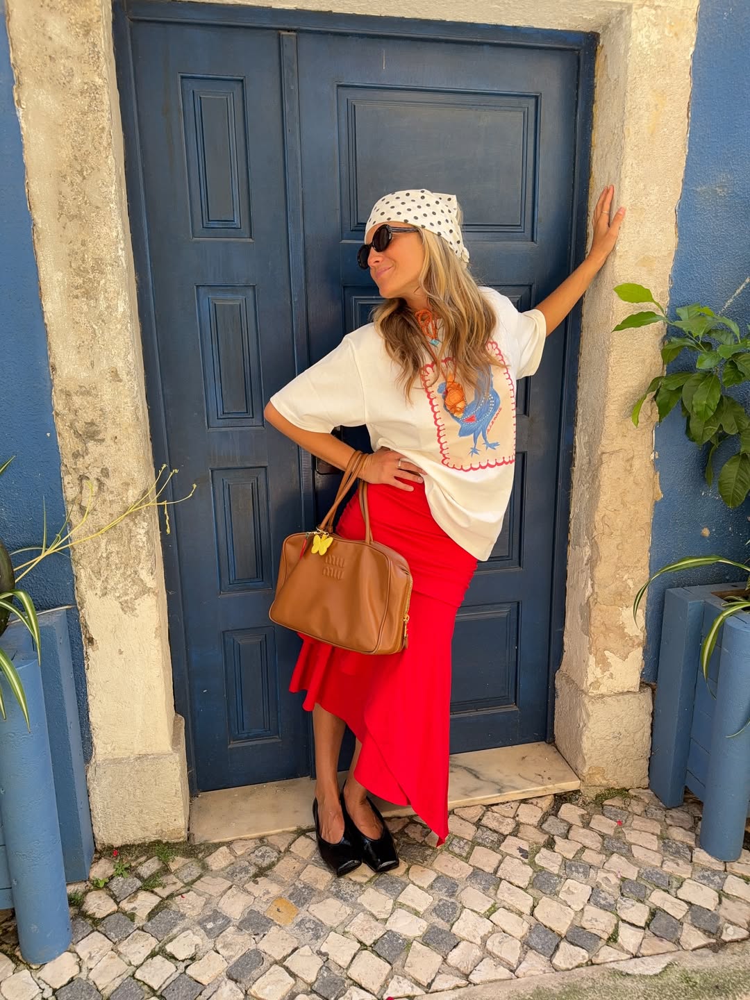 Caetana Botelho Afonso wears red skirt, T-shirt and polka dot headscarf
