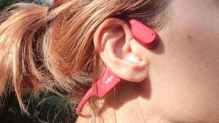 A close-up picture of our reviewer testing the Shokz OpenRun bone conduction headphones
