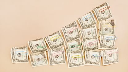 Rolls of dollar bills are arranged in successively higher stacks.