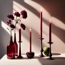 Candlesticks, candles and a vase and flowers in Etsy's 2024 colour of the year, Berry