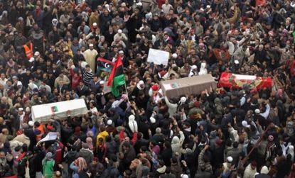 Libyans carry the bodies of three more victims killed during the anti-government protests this week, while leader Moammar Gadhafi refused to step down.