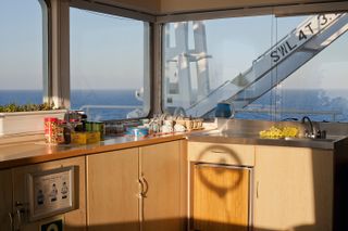 A container ship kitchen counter with windows looking out over the sea.