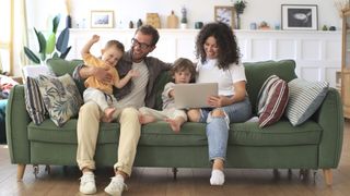 A family browse the internet together on a sofa