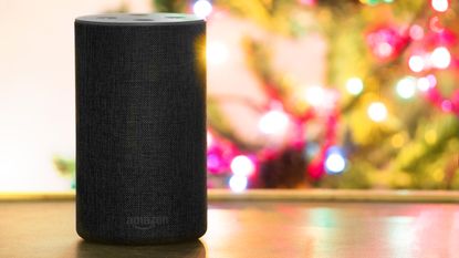 An Amazon echo in front of a Christmas tree