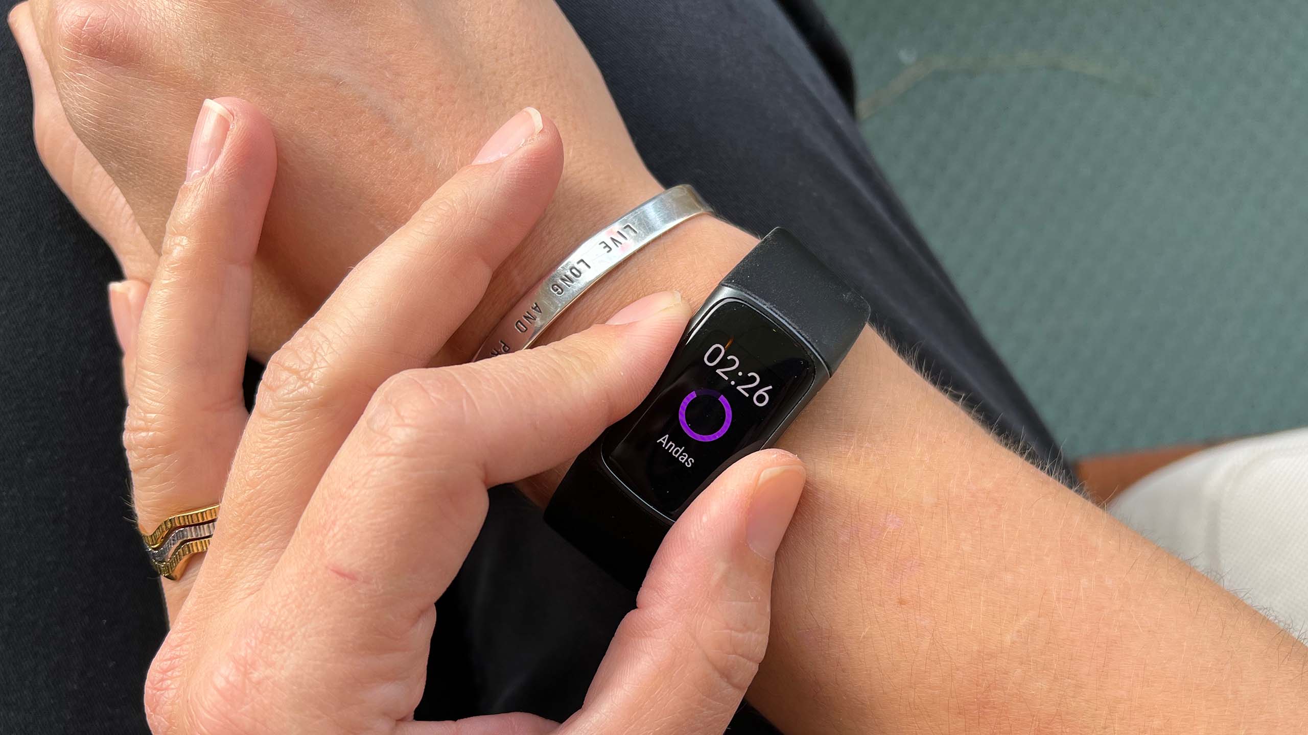 Woman using Fitbit Charge 5 watch