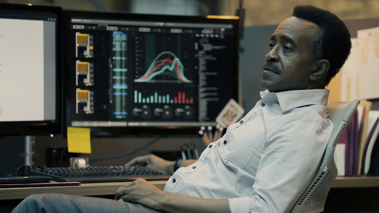 Langston Fleury seated at his A.R.G.U.S. desk in Peacemaker Season 2 finale