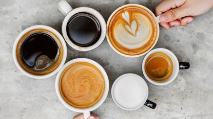 Above Shot Of Hands Holding Coffee Cups On Table 