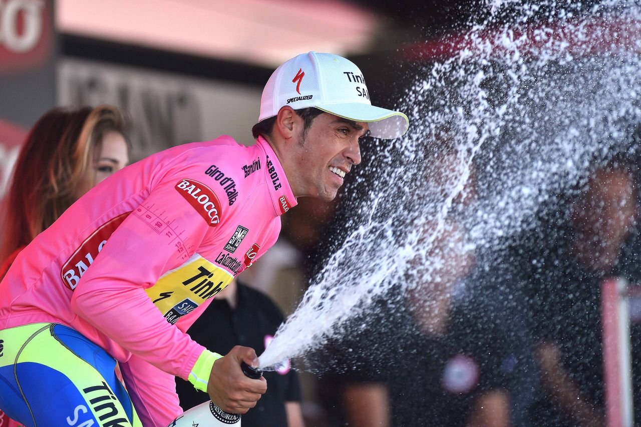 Alberto Contador smiling as he sprays the prosecco