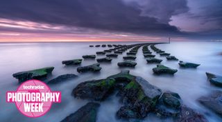 A rocky coastal seascape at dusk