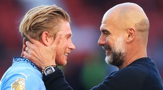 Manchester City manager Pep Guardiola embraces Kevin De Bruyne after the team's 0-0 draw against Manchester United at Old Trafford in April 2025.
