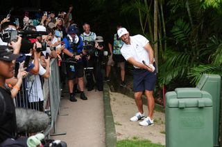 Dustin Johnson pitches out from near a path at LIV Golf Singapore