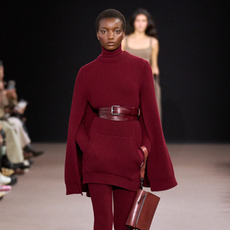 Model on runway wearing burgundy knitted dress