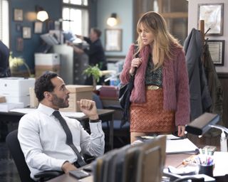 Daniel Sunjata as Detective Karadec and Kaitlin Olson as Morgan Gillory, talking in a police station, in 'High Potential.'