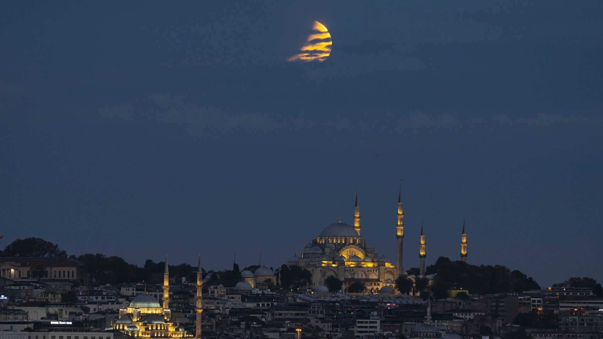 An eclipsed moon shines over Istanbul in Turkiye at night.