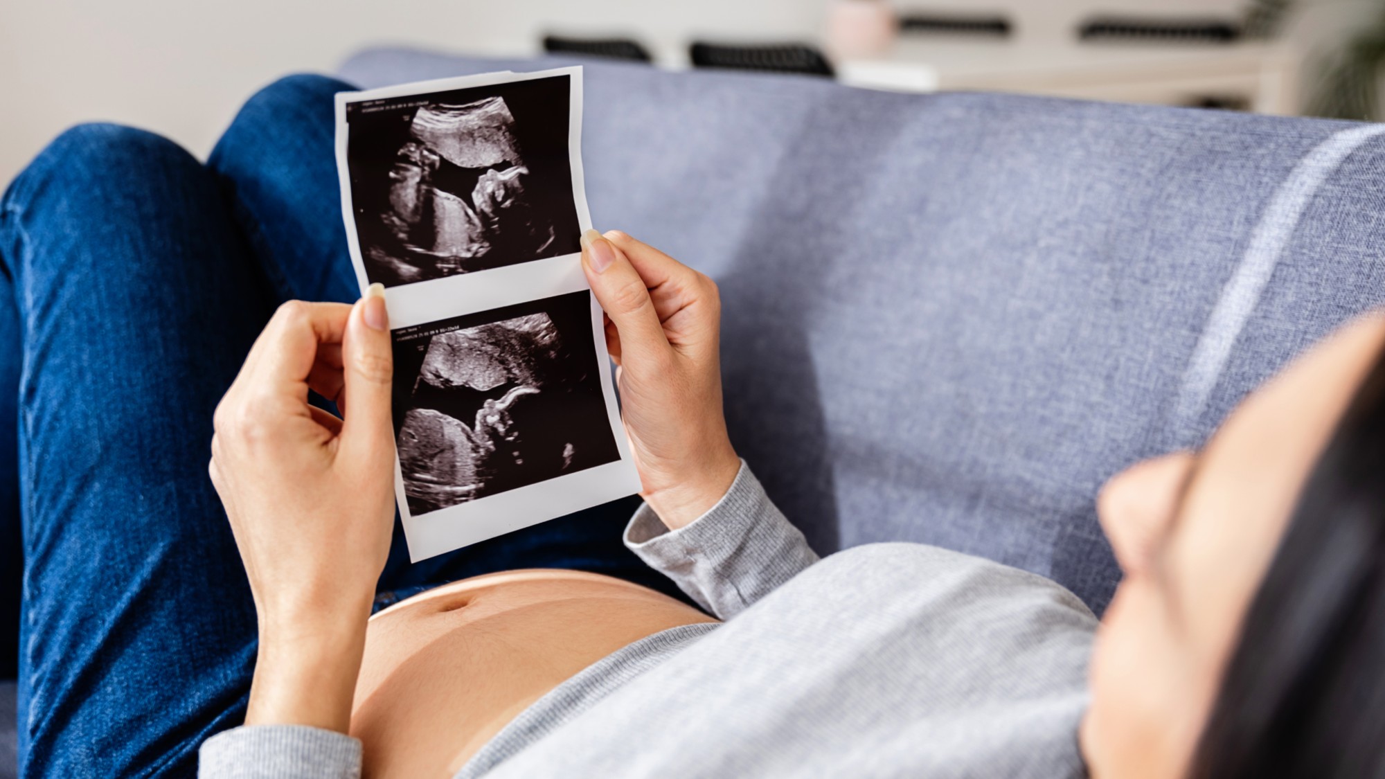 A stock image of a pregnant woman viewing an ultrasound scan.
