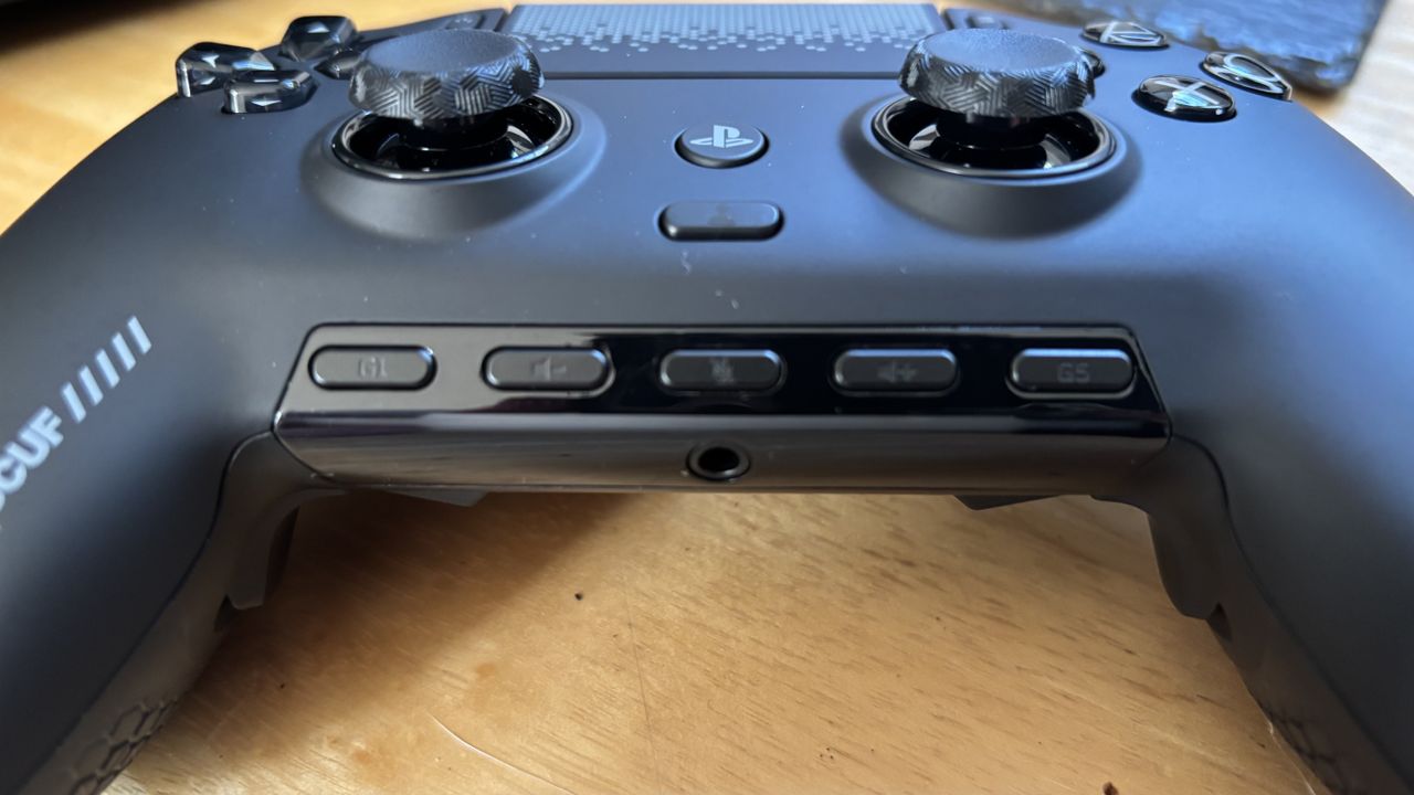 The Scuf Omega PS5 controller sitting on a wooden surface with its front buttons front and centre