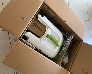 Gtech CLM50 cordless lawn mower inside its original packaging box