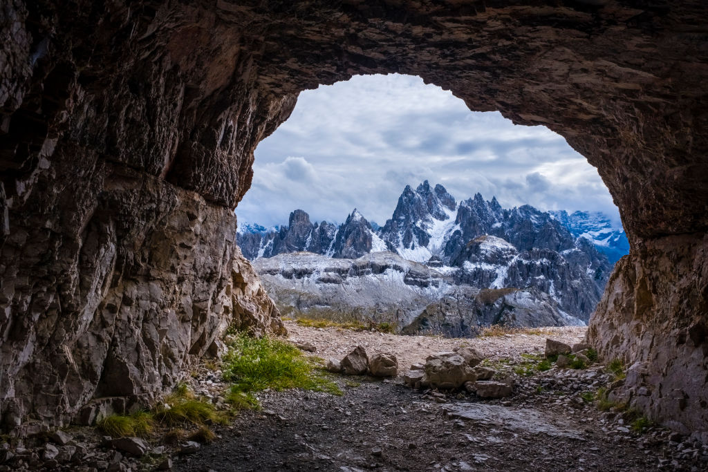 AURONZO DI CADORE, VENETO, ITALY - 2022/09/27: The rocky summits of the mountain Cadini di Misurina, partially shrouded in clouds, covered in fresh snow, seen out of a cave.
The entire Dolomites are part of the Unesco World Heritage. (Photo by Frank Bienewald/LightRocket via Getty Images)