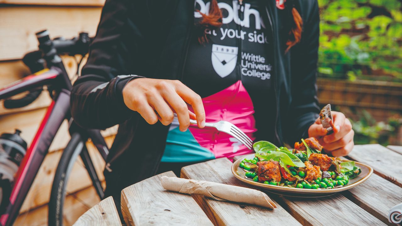 A cyclist tucks into a plate of salad