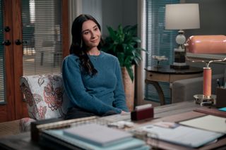 Lilah Richcreek Estrada as Julie, sitting in the director's office at a senior living facility, in episode 107 of A Man on the Inside.