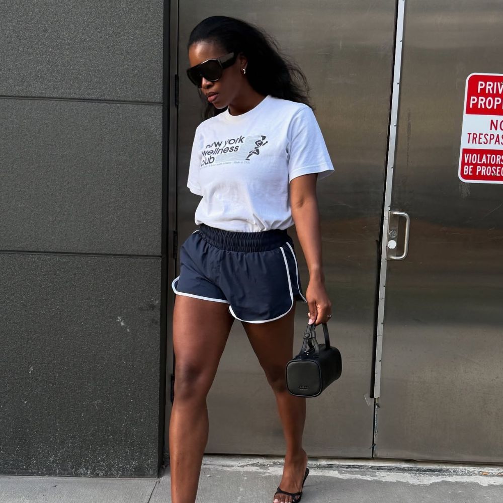 Influencer @nlmarilyn wears a white t-shirt tucked into sports shorts with heeled sandals.