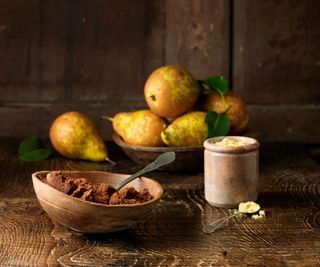 A bowl of pears next to brown sugar