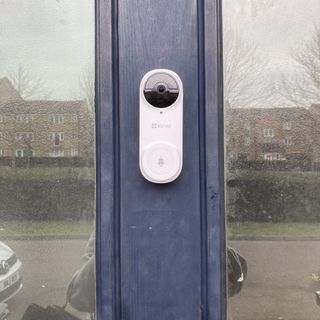 Ezviz DB2 Wireless Video Doorbell mounted to blue doorframe