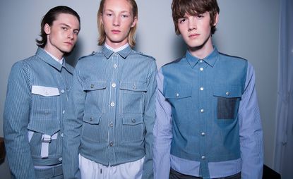 A row of models pose for a picture against a white backdrop